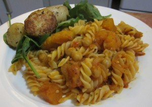 Pumpkin pasta with baked potatoes and leafy greens.